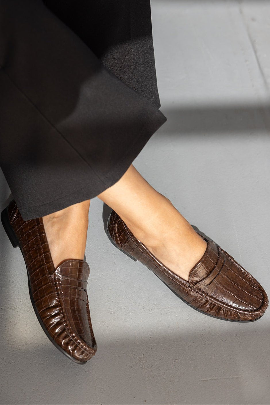 נעלי מוקסין לנשים בצבע חום דמוי עור תנין עם מכנסיים שחורים, אופנת נשים צעירה