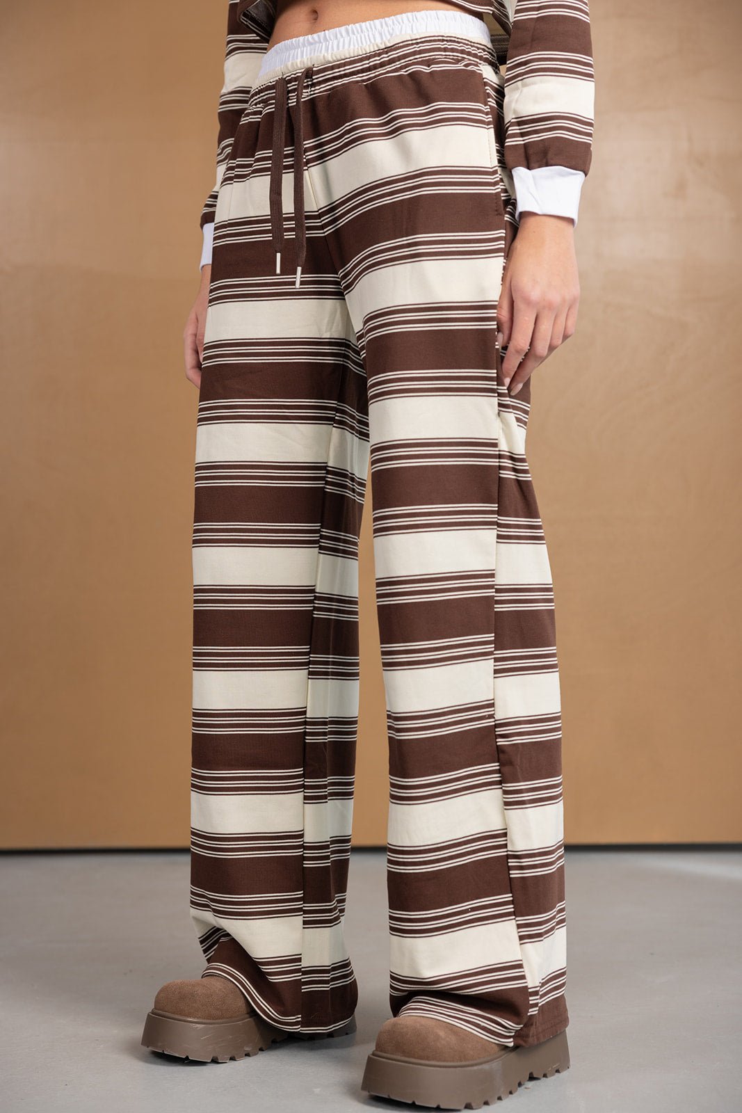 מכנסי נשים רחבים עם פסים חומים ולבנים, בד רך, חגורת גומי ונעליים חומות אופנתיות