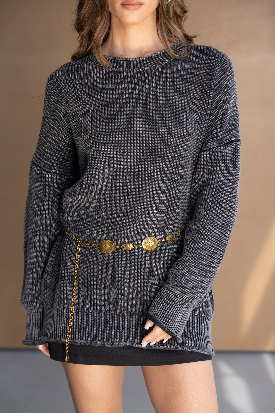 דוגמנית לובשת סוודר אפור עם שרשרת מותן זהובה, אופנה לנשים ולנערות, לוק סתיו חורפי