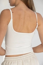 גופיית ספגטי לבנה לנשים בגב חשוף, משולבת עם מכנסי טרנינג בהירים