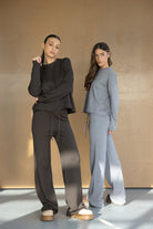 שתי דוגמניות לובשות סט טרנינג אופנתי לנשים בצבעים שחור ואפור, בגדי קז'ואל טרנדים.