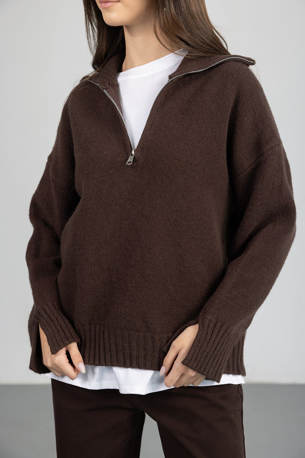 חולצת סוודר חומה לנשים עם רוכסן, נלבשת על חולצה לבנה, אופנת חורף לנערות