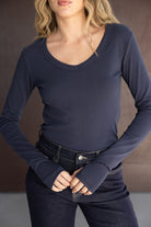 חולצה ארוכה לנשים בצבע כחול כהה עם שרוולים ארוכים וגזרת סקיני, משולבת עם ג'ינס כהה