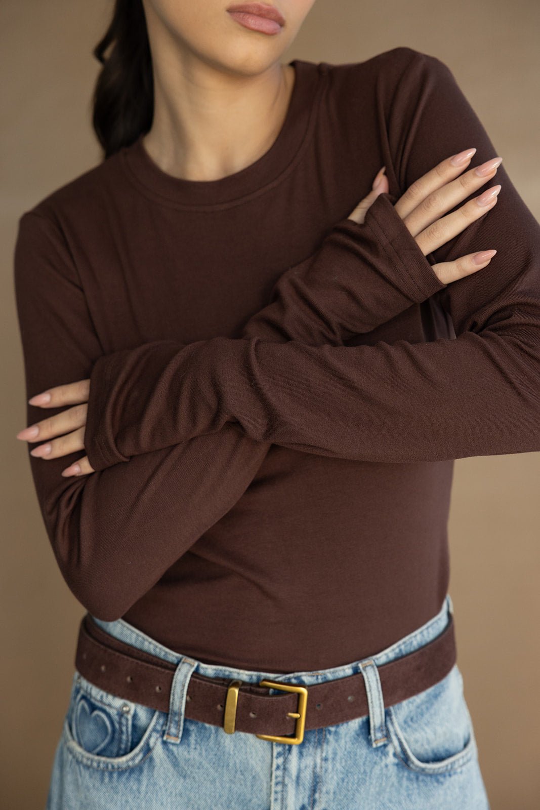 חולצת בייסיק חומה עם שרוולים ארוכים וחגורה חומה על ג’ינס בהיר, אופנת נשים