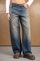 ג'ינס נשים בגזרה רחבה בצבע כחול משופשף, משולב עם מגפוני פלטפורמה חומים