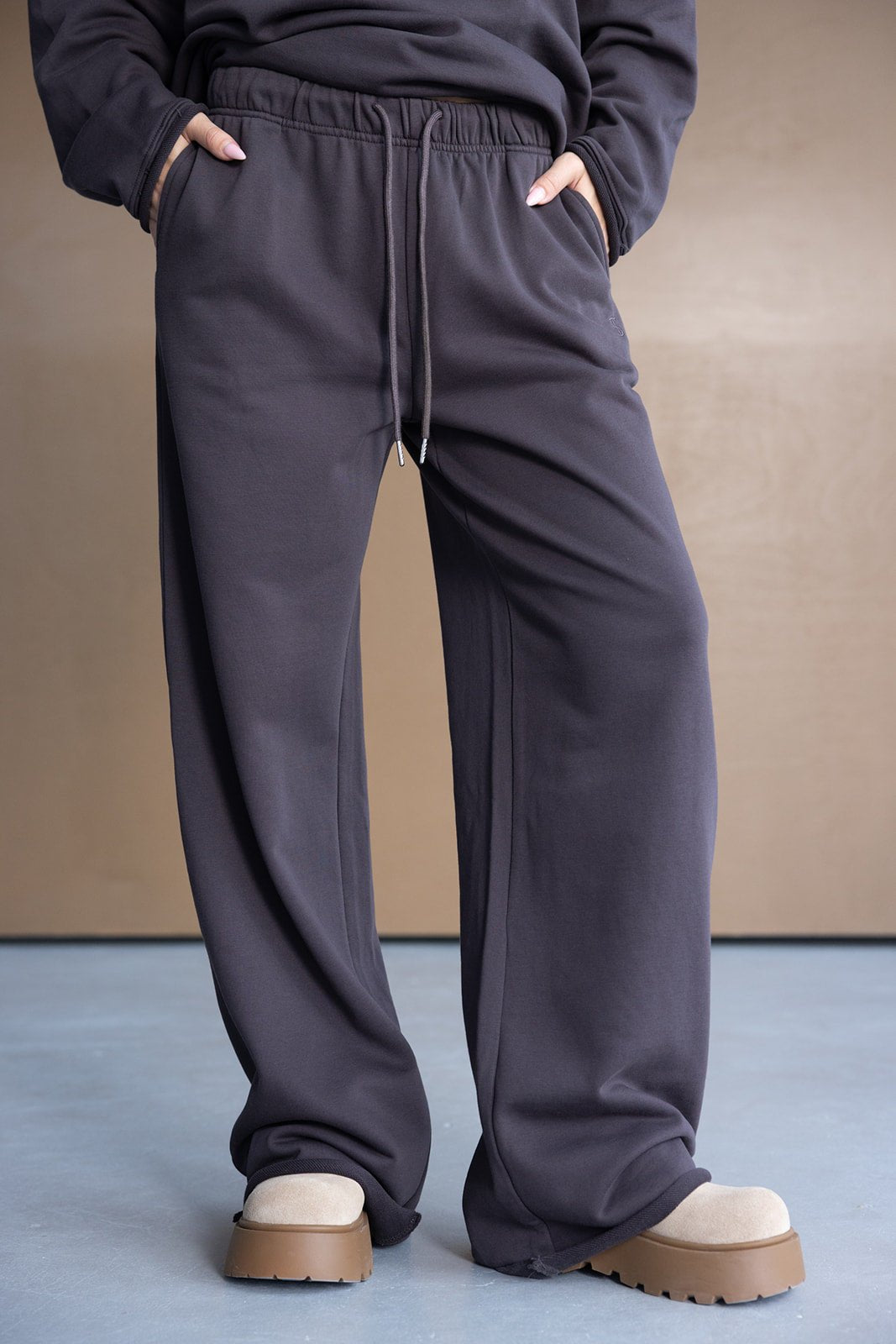 מכנסי טרנינג נשים בגזרה רחבה, צבע אפור כהה, עם גומי ושרוך, נעלי פלטפורמה בז'