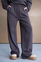 מכנסי טרנינג נשים בגזרה רחבה, צבע אפור כהה, עם גומי ושרוך, נעלי פלטפורמה בז'