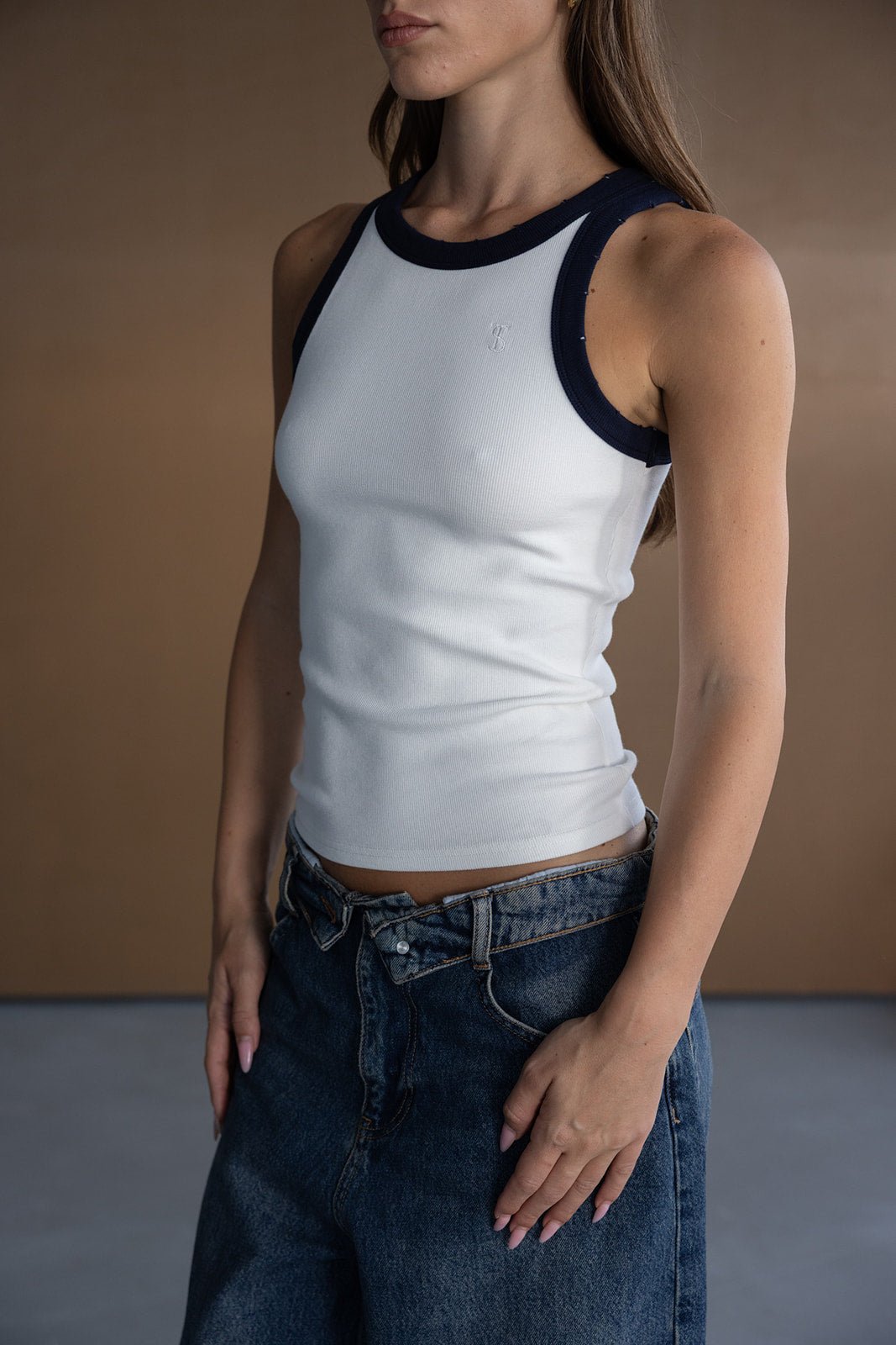 גופיית נשים לבנה עם גבול כחול כהה ומכנסי ג'ינס רחבים, אופנת קיץ לנערות