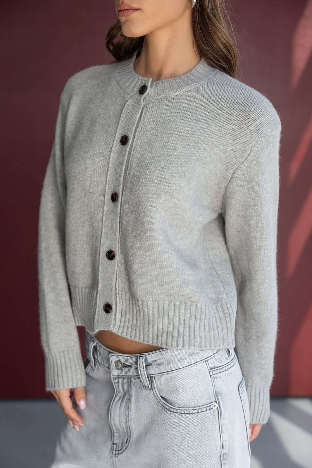 קרדיגן אפור לנשים עם כפתורים כהים, בשילוב חצאית ג'ינס אופנתית