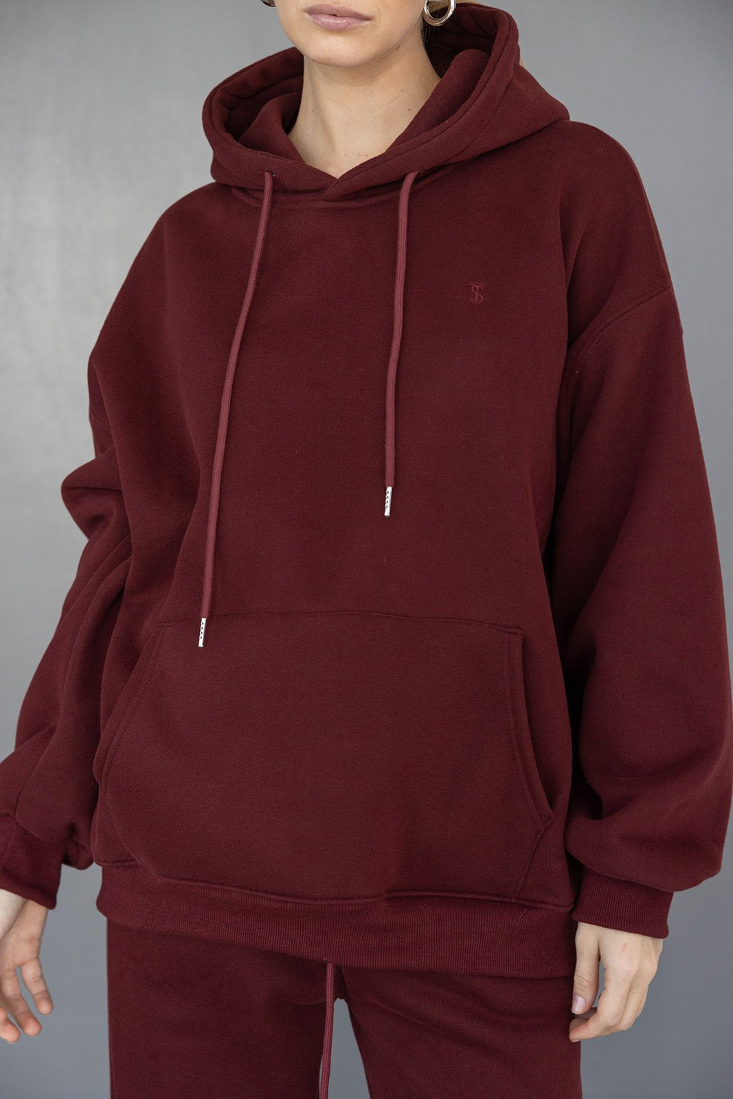 אישה לובשת קפוצ'ון בורדו אופנתי עם כיס קדמי ומכנס תואם, סט בגדי נשים אופנה חורפית