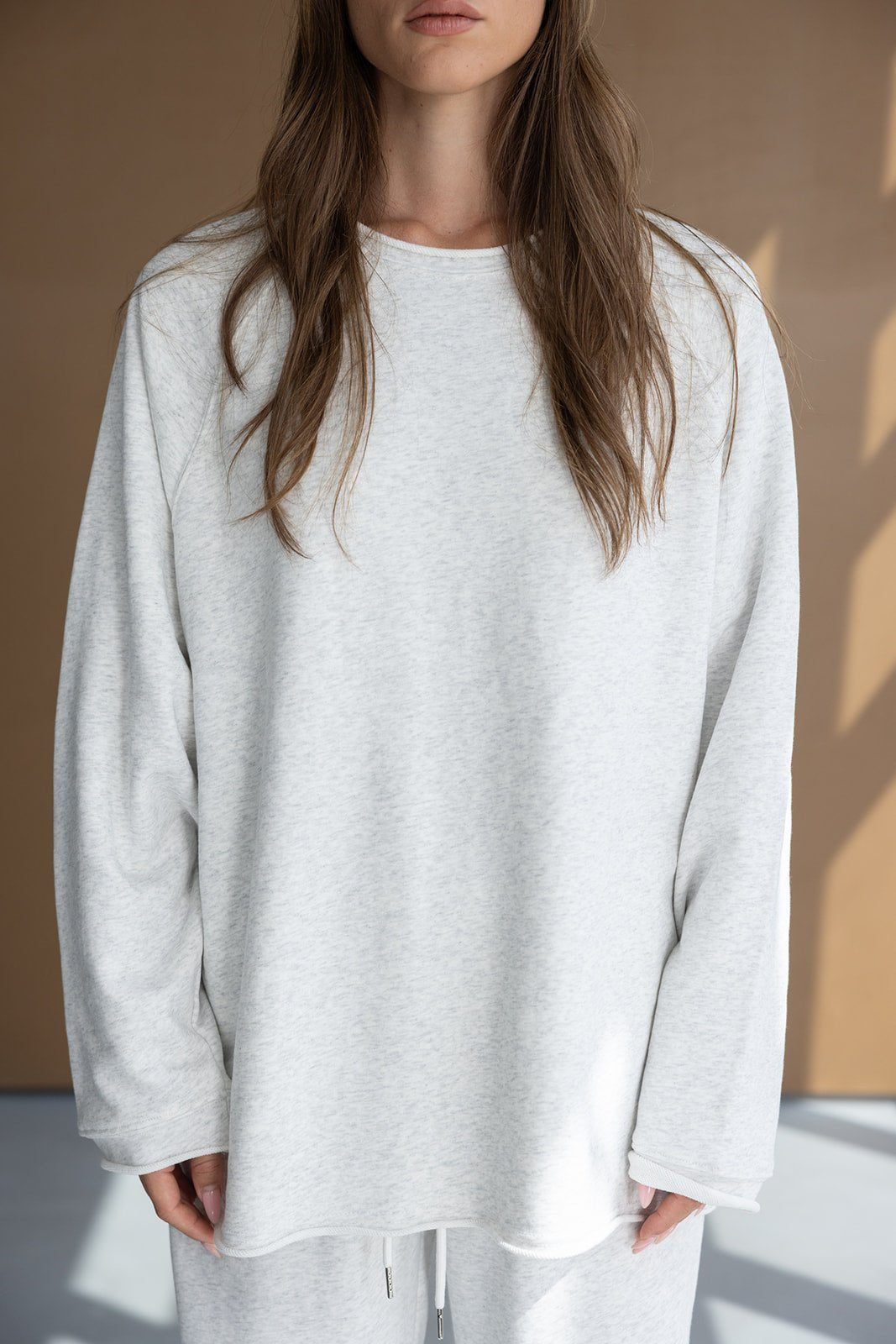 דוגמנית לובשת חולצת טרנינג לבנה עם שרוולים ארוכים, אופנת נשים בסגנון קז'ואל