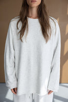 דוגמנית לובשת חולצת טרנינג לבנה עם שרוולים ארוכים, אופנת נשים בסגנון קז'ואל