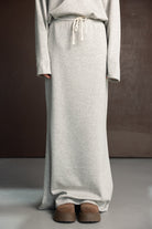 חצאית לנשים בצבע אפור בהיר מבד רך עם גומי וקשירה, נעלי פלטפורמה חומות