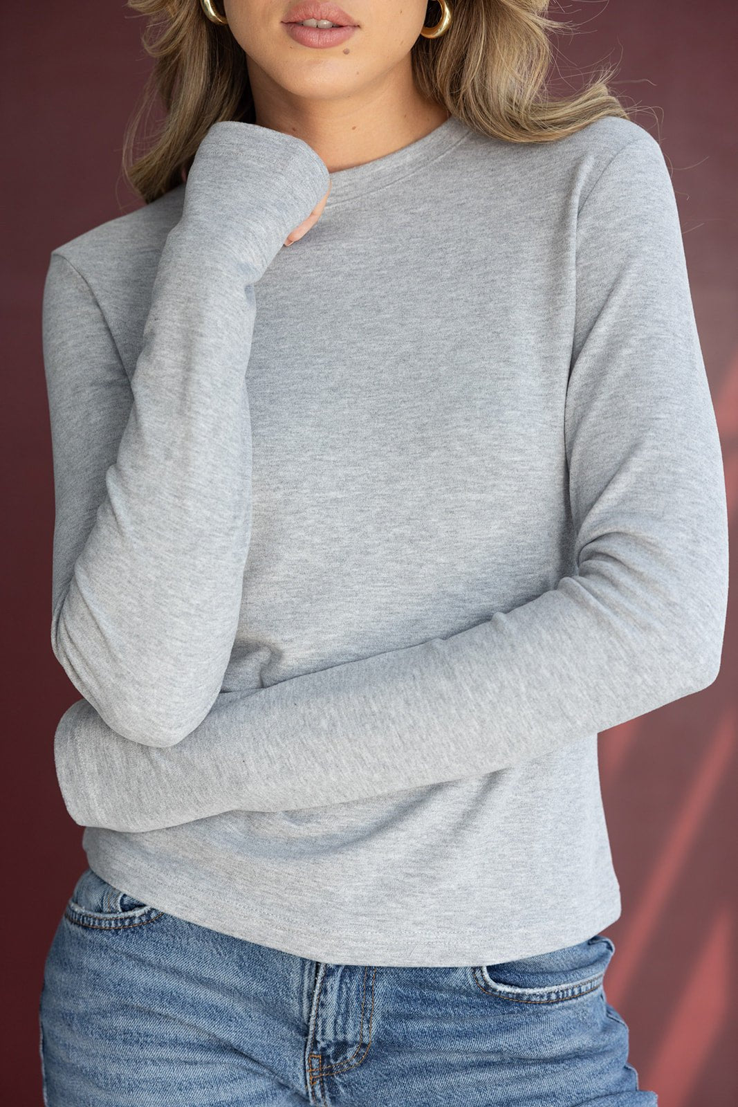 אישה עם חולצת שרוול ארוך בצבע אפור וג'ינס תכלת, אופנה לנשים צעירות