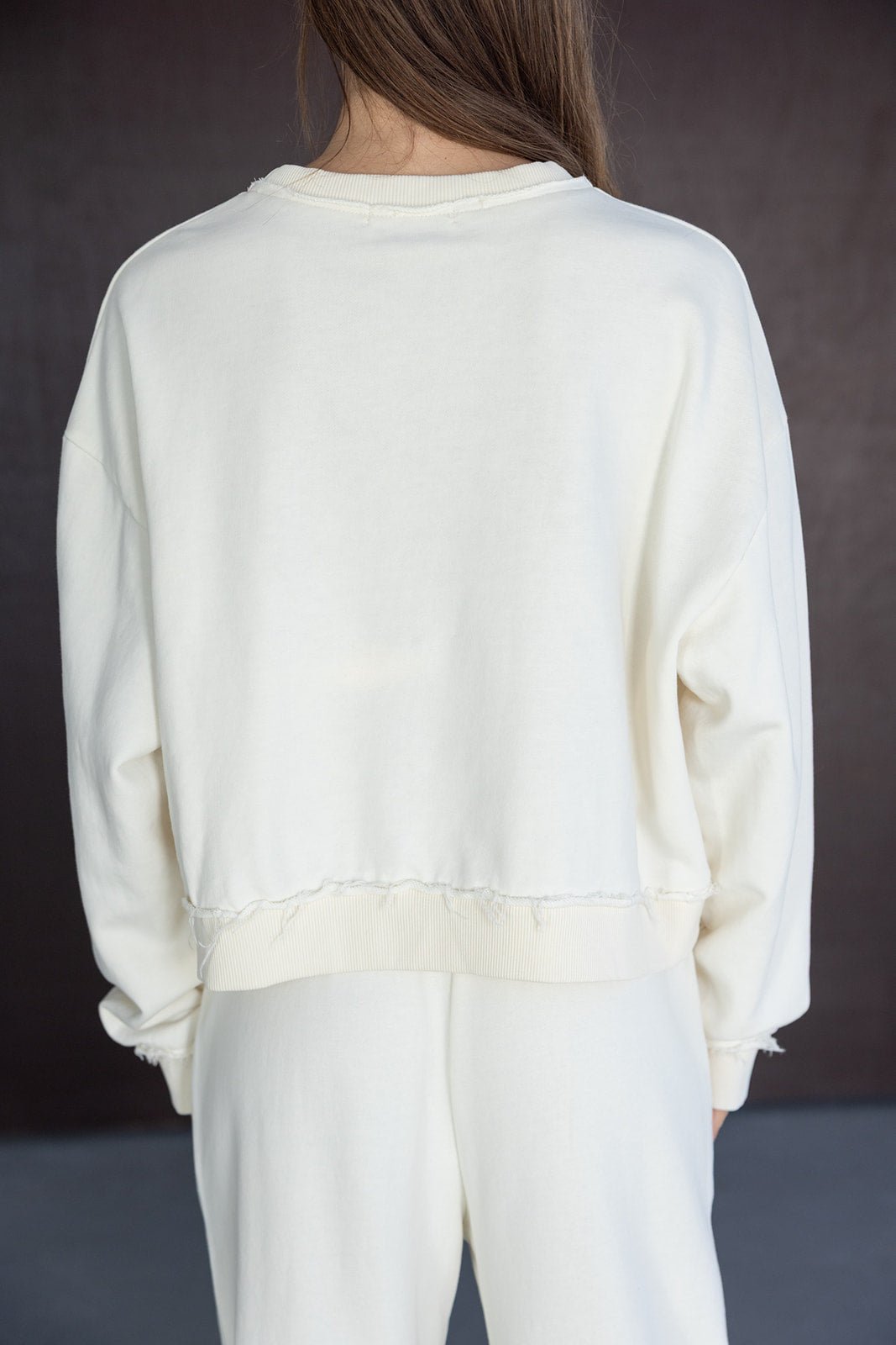 אישה לבושה בסט טרנינג לבן ליום יום, חולצת שרוול ארוך עם גימור קרוע, אופנת נשים צעירות