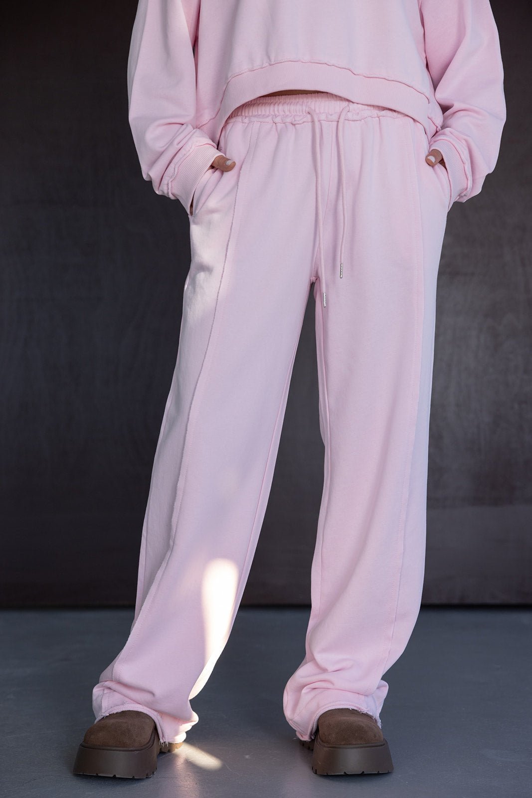 מכנסי טרנינג ורודים לנשים עם גומי במותן, בגזרת ספורט אופנתית, רקע כהה