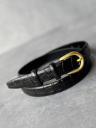 חגורת נשים אופנתית דמוי עור שחור עם אבזם זהב בעיצוב קלאסי, על רקע אפור