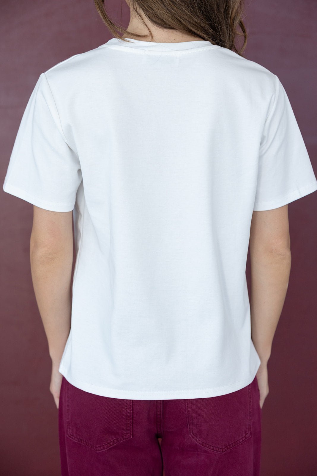 חולצה קצרה לבנה לנשים עם גב חלק, מכנסי בורדו, רקע סגול, אופנה צעירה