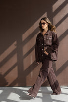 דוגמנית לובשת חליפת מכנסיים וז'קט חום לנשים, אופנה עכשווית, תאורת סטודיו