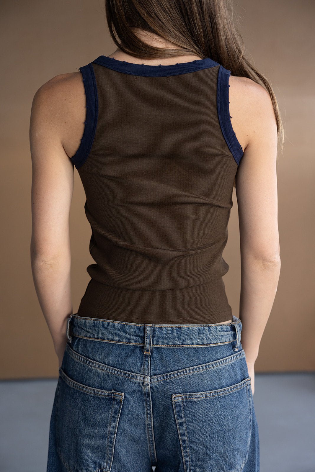 גופיית נשים חומה בגזרת סינגל, שוליים כחולים, עם ג'ינס באז' אופנתי לצעירות