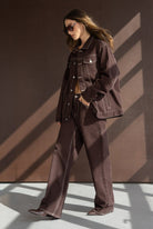 אישה לובשת ז'קט ומכנסיים חומים רחבים, אופנה לנשים, לוק סתיו עדכני