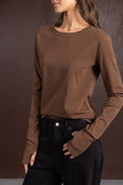 חולצת נשים ארוכה בצבע חום בשילוב מכנסי ג'ינס שחורים, אופנת חורף לנשים