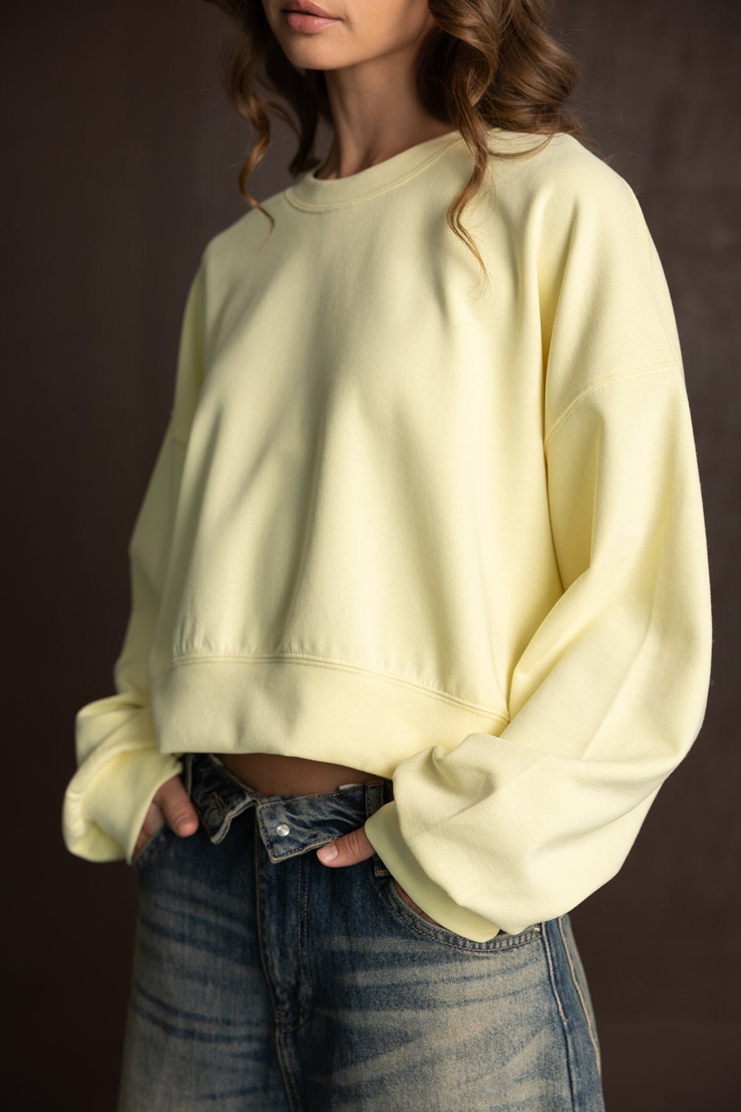 חולצת סווטשירט צהובה לנשים עם שרוולים רחבים, משולבת עם ג'ינס בגזרה גבוהה