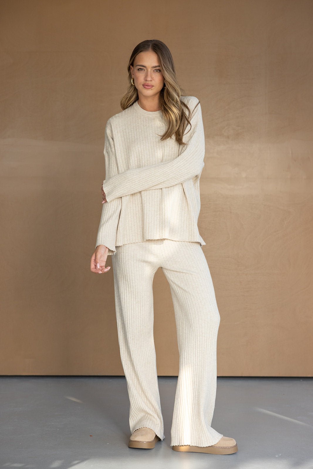 דוגמנית לובשת סט חליפת טריקו מחורץ בצבע בז', אופנה לנשים בסגנון קז'ואל חורפי