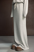 חצאית ספורט ארוכה בצבע אפור לנשים עם שרוך קשירה ונעליים חומות אופנתיות