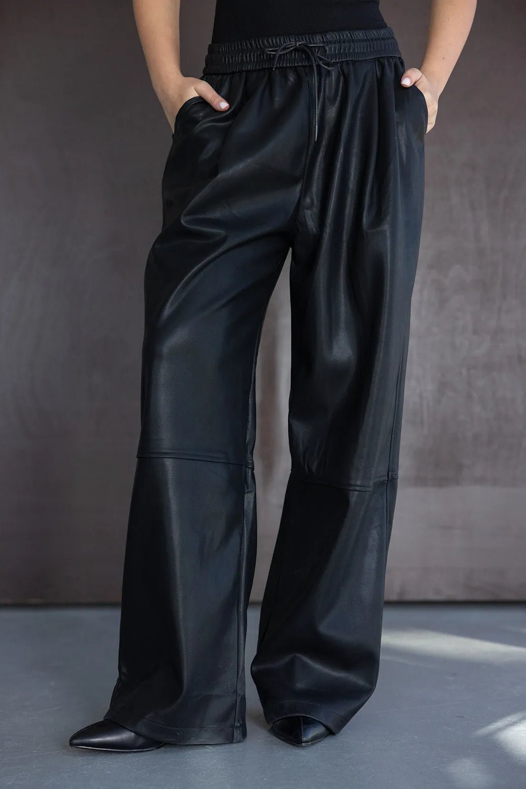 מכנסי נשים רחבים דמוי עור בצבע שחור עם גומי במותן, מראה אופנתי ואלגנטי