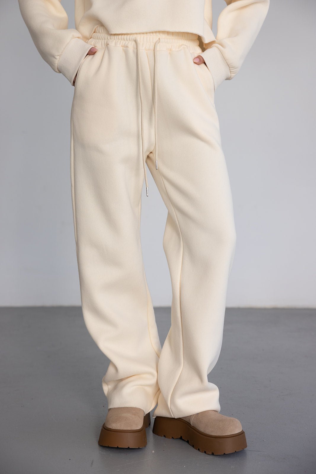 מכנסי טרנינג נשים בצבע שמנת עם שרוך גומי, נעלי פלטפורמה בז', מראה אופנתי ואורבני