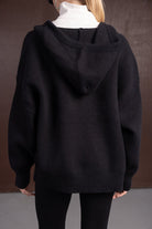 חולצת קפוצ׳ון שחורה לנשים, גזרה רחבה ובד סריג, צילום גב על רקע חום