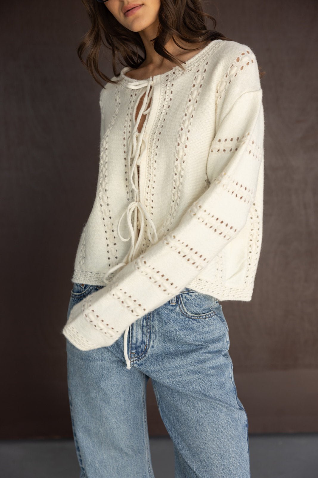 סריג קרם אופנתי עם שרוך במחשוף, משולב חורים, משודך לג'ינס בגזרה רחבה לנשים