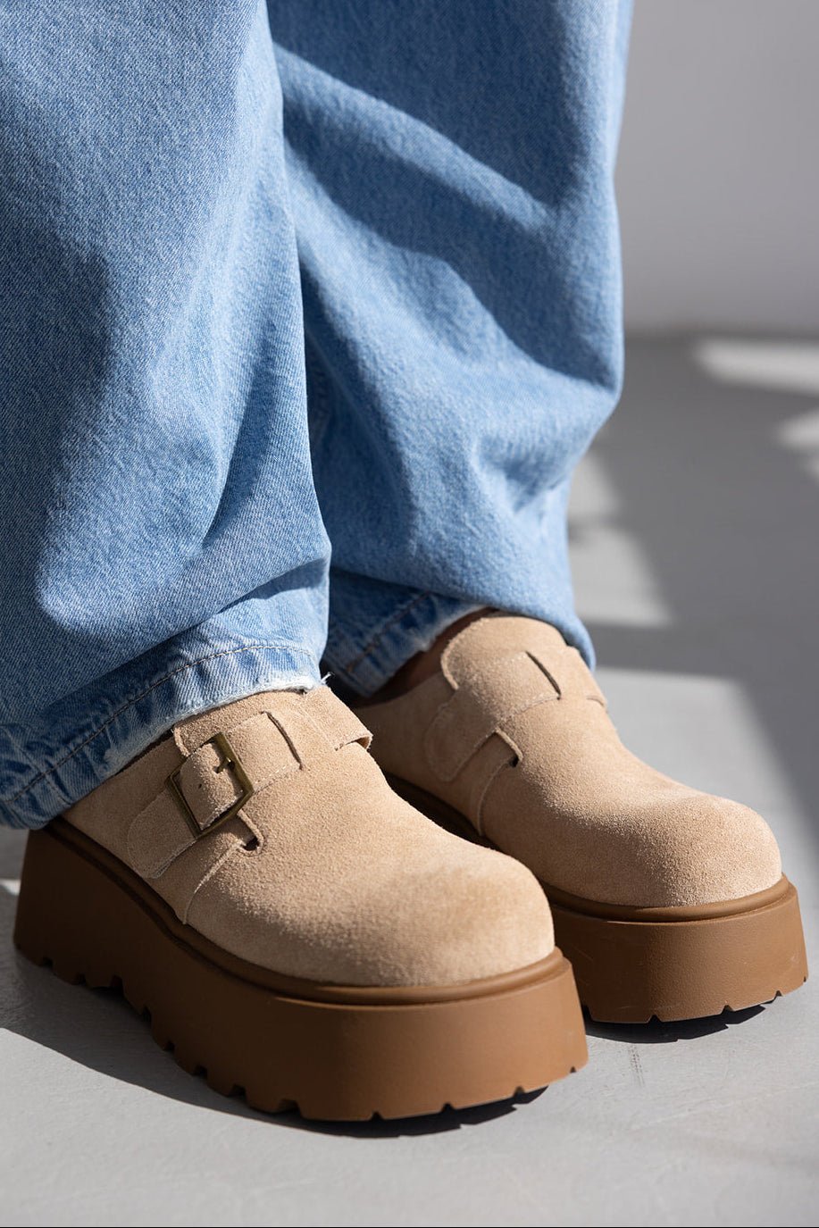 נעלי מוקסין נשים בז׳ עם סוליה עבה ובקלס סגור, בשילוב ג׳ינס כחול רחב