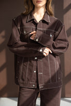 אישה לובשת ג'קט וחליפה חומה, תפירה מודגשת, אופנת נשים לנערות