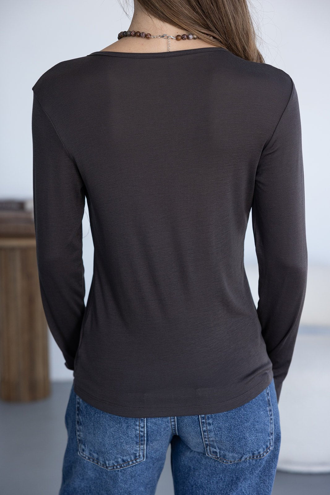 חולצת נשים ארוכה בצבע שחור וג'ינס בגזרת נשים, מבט מהגב, אופנה לנערות