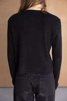 חולצת נשים שחורה ארוכה מבד ריב עם שרוולים ארוכים, נראת מאחור, אופנת קז'ואל