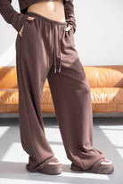 מכנסי טרנינג חומות לנשים בגזרה רחבה עם שרוך במותן, נעלי בית חומות, אופנת נוער