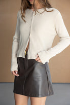 דגם אופנה לנשים עם ס cardigan בצבע קרם וחצאית קצרה דמוי עור חום, מראה שיקי ואלגנטי