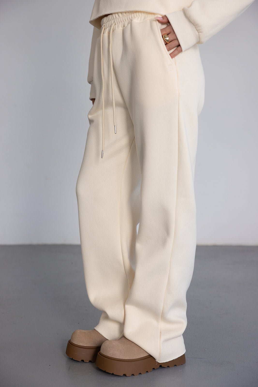 מכנסי טרנינג נשים בצבע שמנת עם גומי במותן ונעליים שטוחות חומות, אופנת רחוב יומיומית