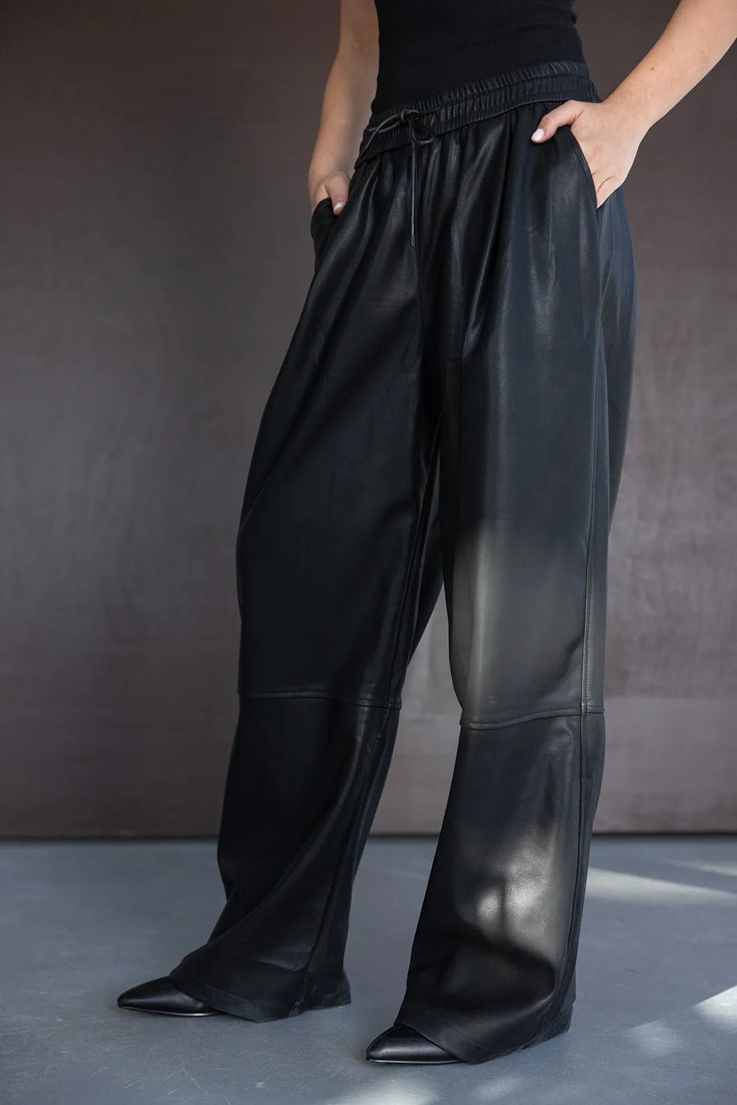 מכנסי עור דמוי רחבים לנשים בצבע שחור עם גומי במותן, אופנת חורף 2024