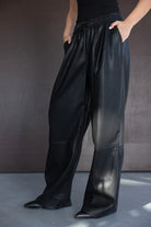 מכנסי עור דמוי רחבים לנשים בצבע שחור עם גומי במותן, אופנת חורף 2024