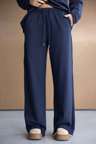 מכנסי טרנינג נשים בצבע כחול כהה רחבים עם שרוך למותן, לוק קז'ואל אופנתי