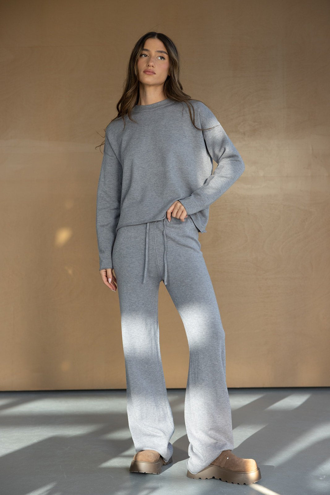 דוגמנית לובשת סט טרנינג אפור לנשים, חולצה ארוכה ומכנסיים, טרנדים באופנה לנערות