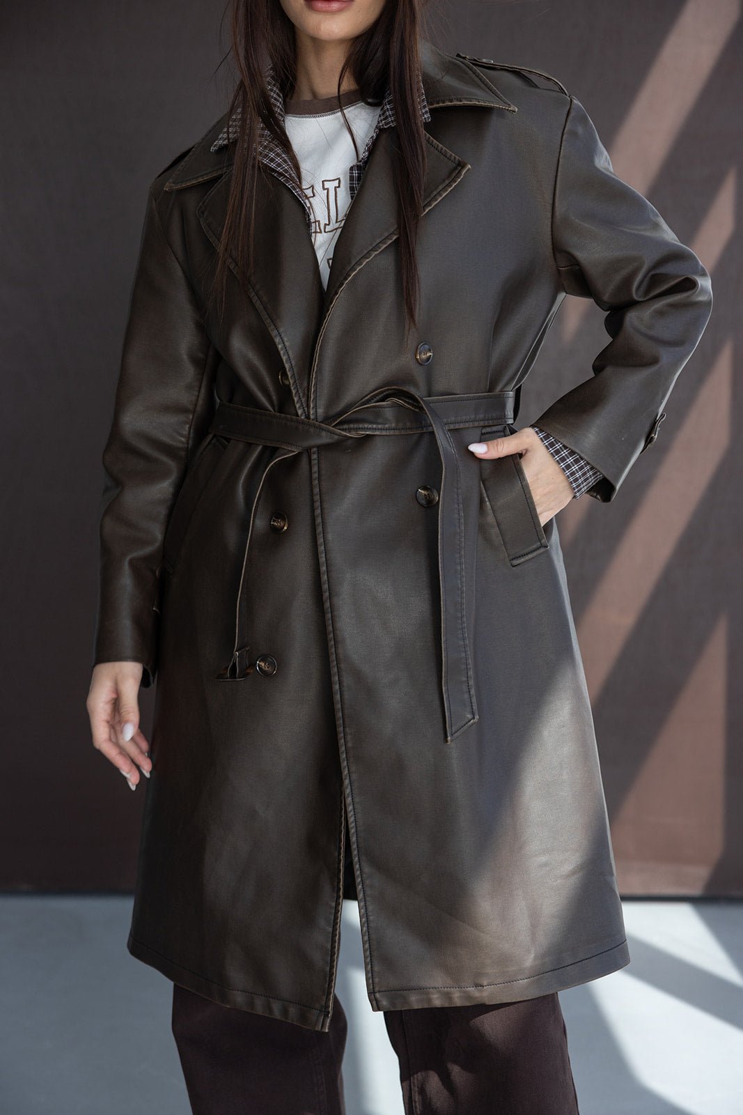 מעיל טרנץ' לנשים דמוי עור בצבע חום כהה, גזרה אופנתית עם חגורה, צילום אופנה