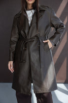 מעיל טרנץ' לנשים דמוי עור בצבע חום כהה, גזרה אופנתית עם חגורה, צילום אופנה