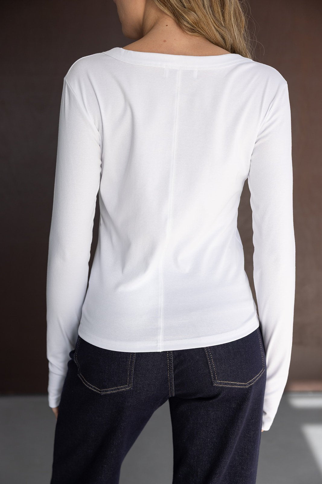 חולצת שרוול ארוך לבנה לנשים עם ג'ינס כהה, צילום גב, אופנת נשים ונערות
