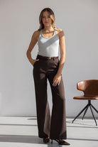 אישה עם גופיית סריג אפורה ומכנסיים חומים רחבים, אופנה לנשים צעירות, צילום בסטודיו