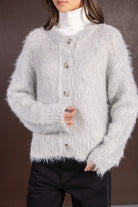 קרדיגן נשים סריג פלאפי בצבע אפור בהיר עם כפתורים, חולצת גולף לבנה ומכנסיים שחורים