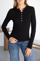 חולצת נשים שחורה עם שרוולים ארוכים וכפתורים, משולבת עם ג׳ינס לאופנת קז'ואל